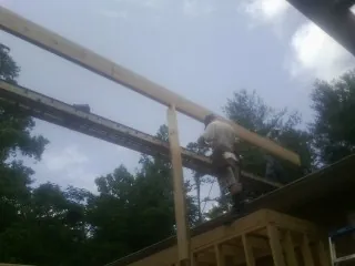 Carpenter setting a ridge beam over a new addition frame — Ice Dam Removal by Roofing Brothers in Carman