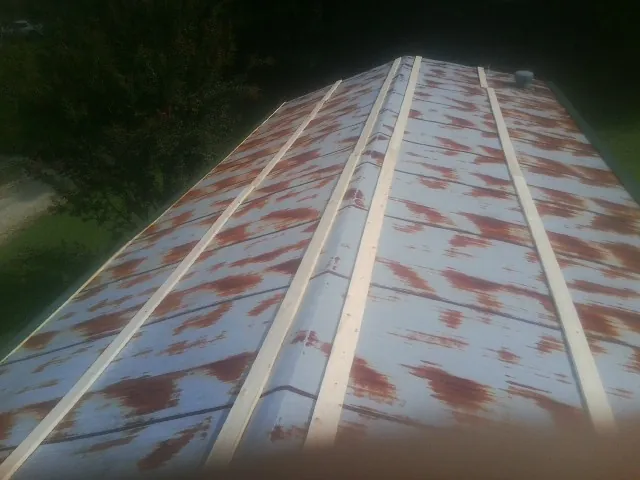 Rusted metal roof panels with new wood purlins before replacement — Storm Damage Roof Repair in Carman by Roofing Brothers