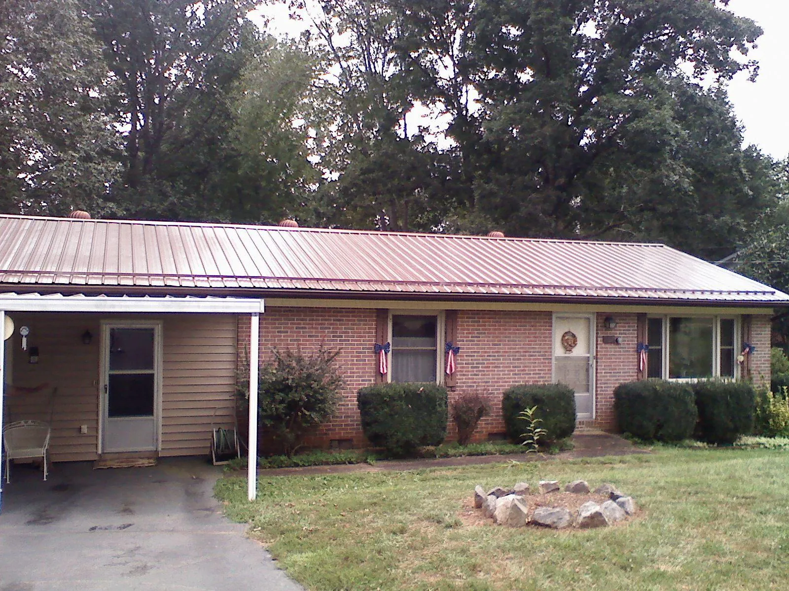 Bronze metal roof and carport on a brick ranch home — Roof Repair work by our crew in Carman